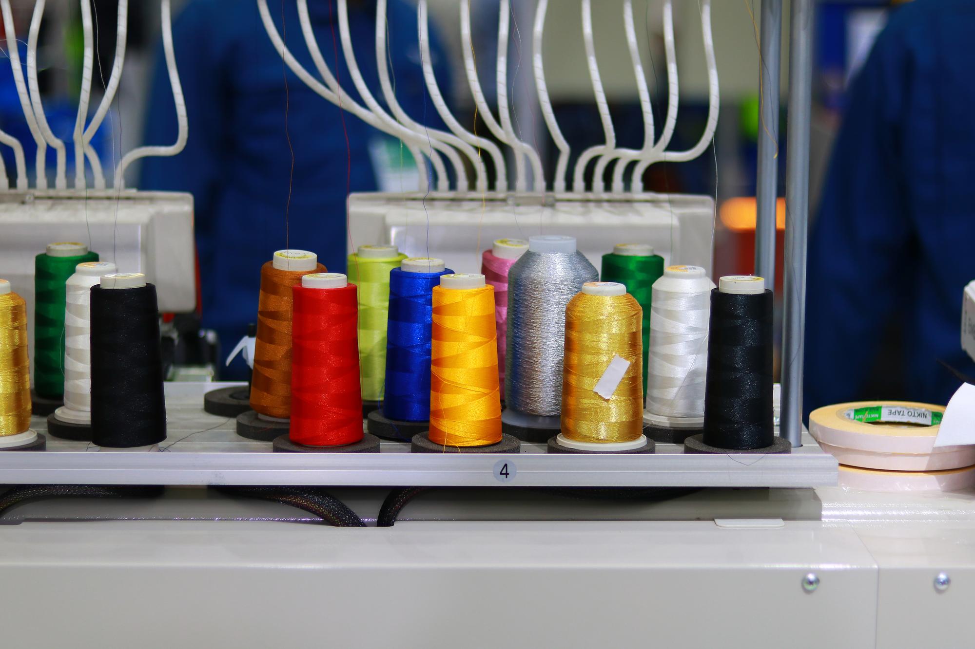 workspace with embroidery machines and thread spools